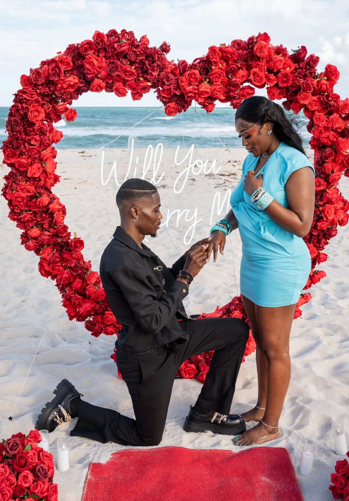 The couple shares a close moment with the ring during their beach proposal.